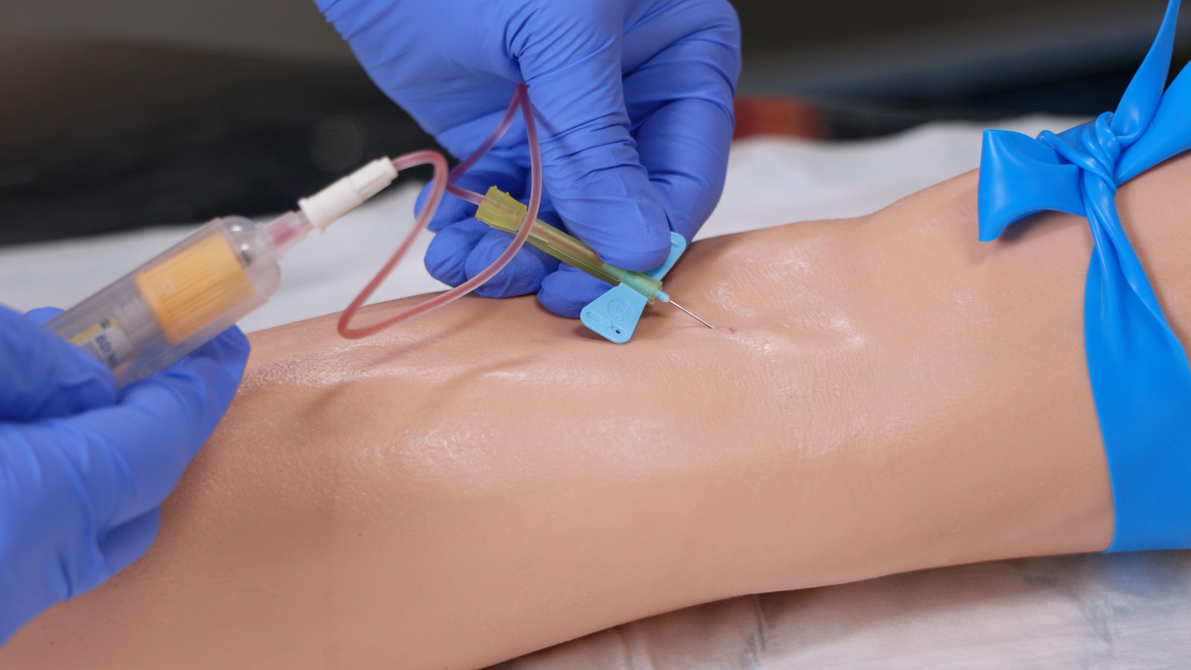 A part task training device is used to practice the skills of Phlebotomy