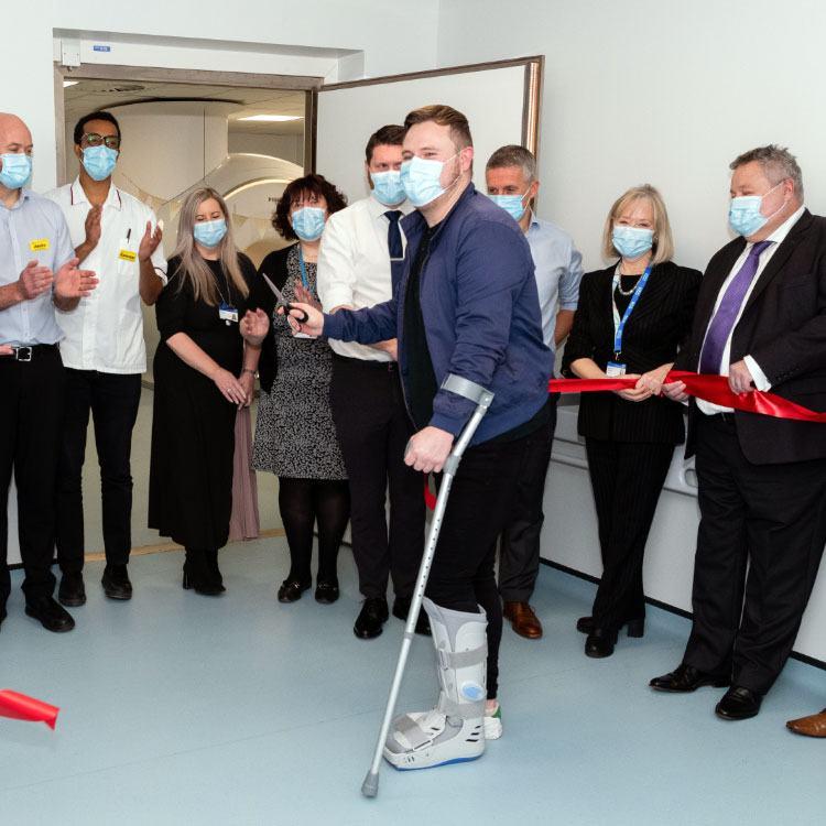 Heartlands Treatment Centre first patient, Richard Mullen cuts a ribbon with UHB staff present to celebrate the occasion