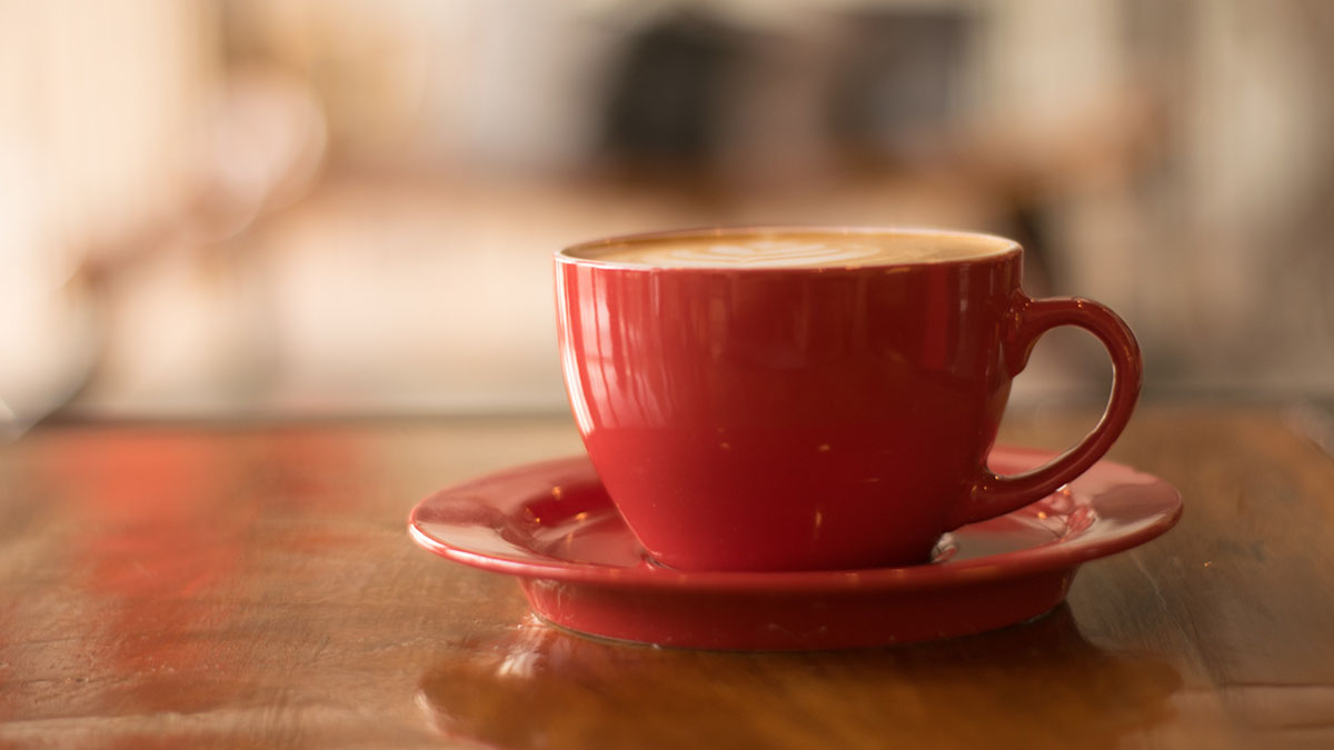 Hot drink in a mug and saucer on a table
