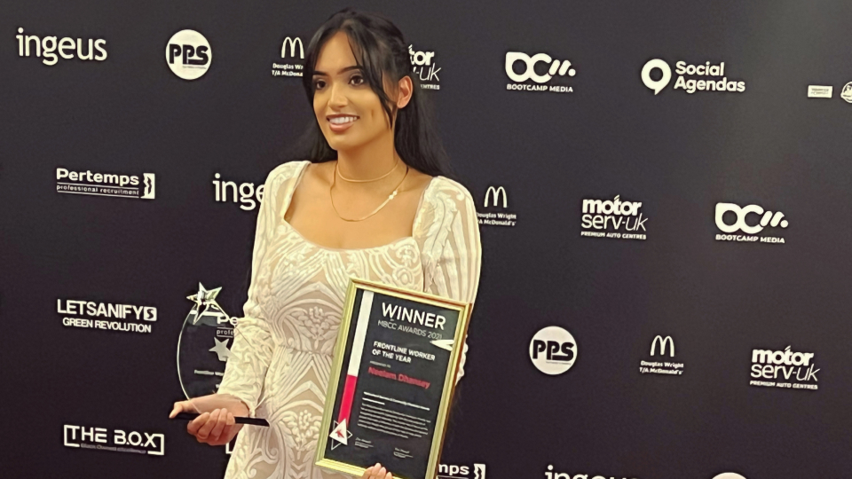 Neelam Dhansey holding her award on the MBCC awards red carpet