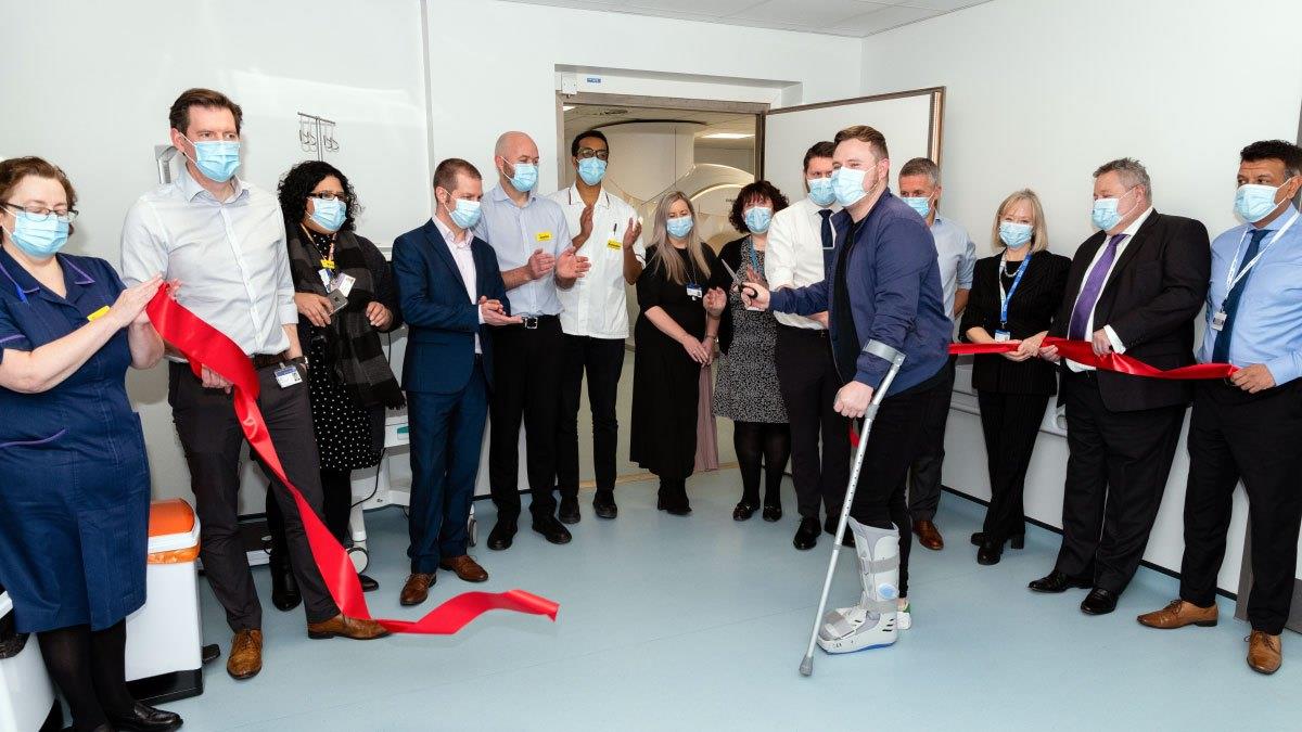 Heartlands Treatment Centre first patient, Richard Mullen cuts a ribbon with UHB staff present to celebrate the occasion