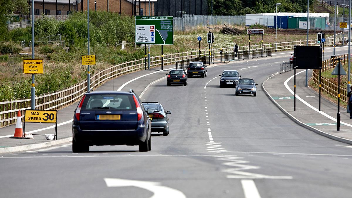 Cars on Aston Webb Boulevard approaching the roundabout serving Queen Elizabeth Hospital Birmingham
